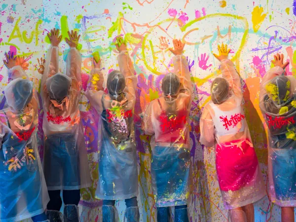 Gruppe wirft Farbe beim Action Painting im Group Splash Room des Artroom Menden